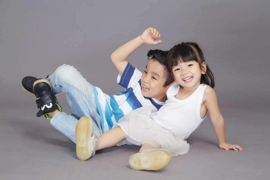 a healthy boy and girl two kids taking a photo together looking happy after kinesiology